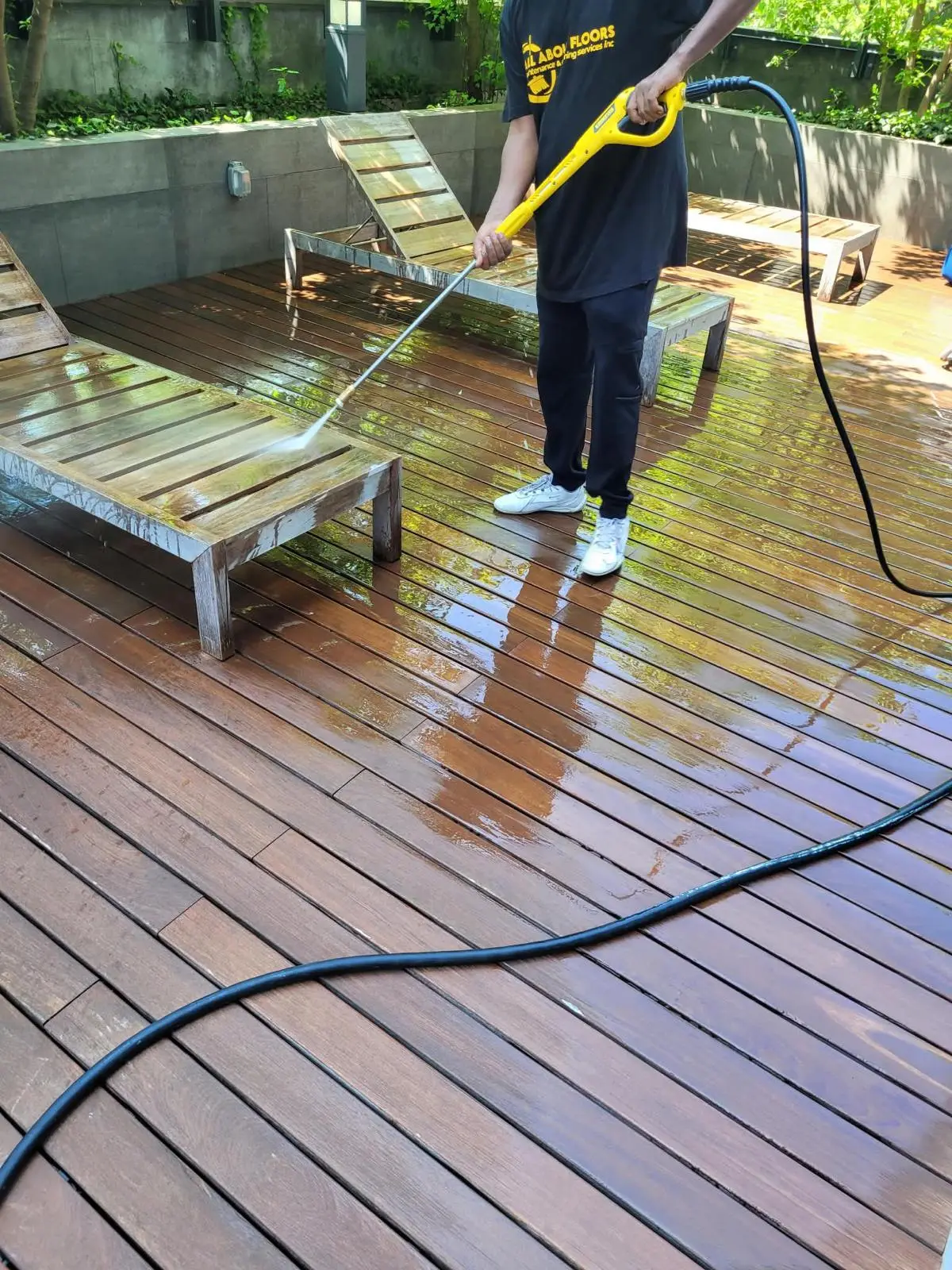 AAFM staff member pressure washing an outdoor rooftop deck